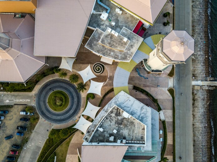 Experience the elegance of Il Corso Lifestyle Mall from above, where modern architecture meets the serene waterfront.
