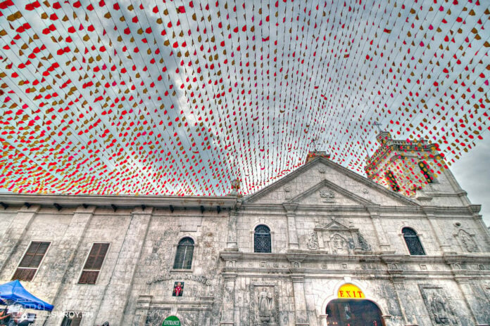 The exterior of the Basilica Minore del Sto. Niño beautifully decorated with festive banners, welcoming visitors and devotees.