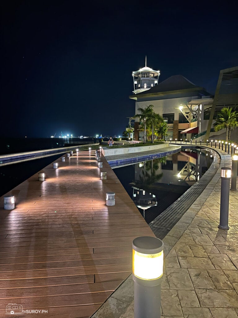 The lighthouse at night shines light to the sea. 