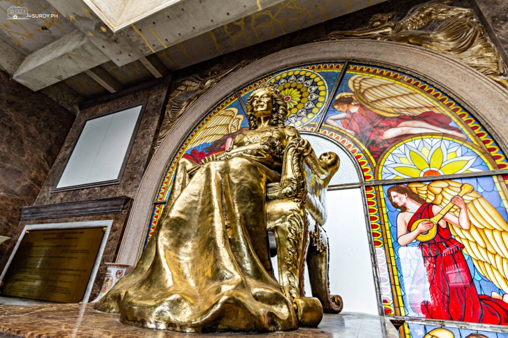 The 9-foot golden statue of Leah shines brightly inside the Temple of Leah, symbolizing eternal love and devotion, surrounded by intricate stained glass art that enhances its majestic beauty.