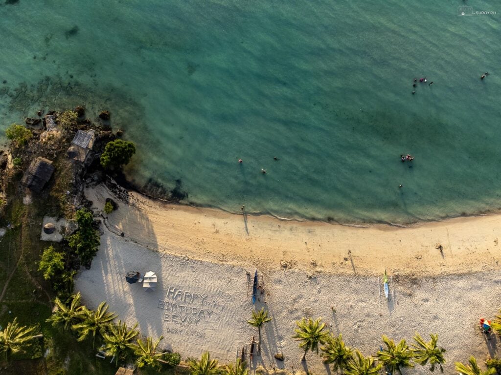 The beach has powdery white sand and plenty of trees along the beachfront.