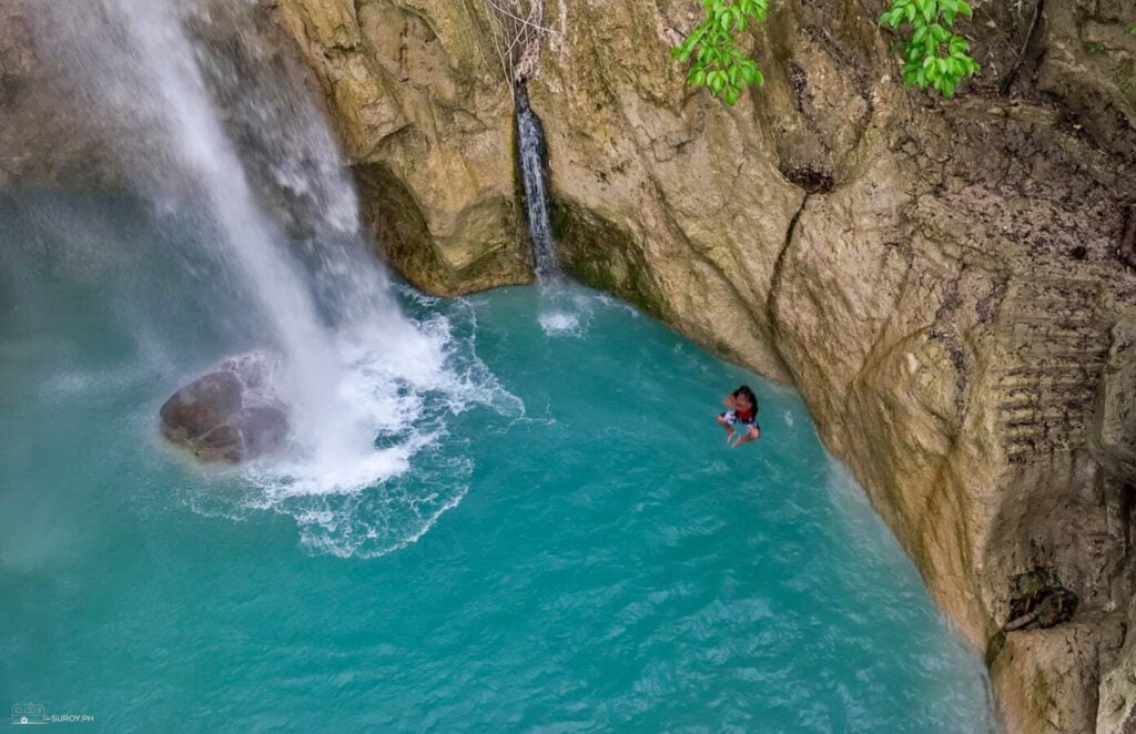 The base of Inambakan Falls where the water strikes a large boulder in a turquoise basin