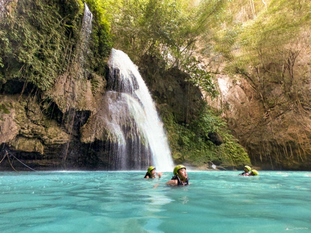 The main drop of Kawasan Falls with swimmers in the turquoise pool at its base