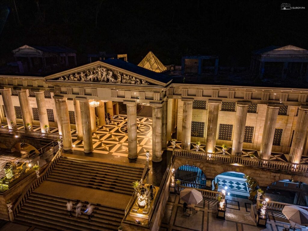 The beautiful Roman-inspired pillars of the temple at night with the pyramid at the back housing the chandelier of Leah. 