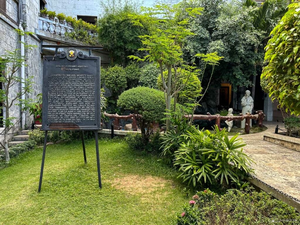 A historical marker in the serene garden of the church, highlighting the significance of the Augustinian presence in the Philippines.