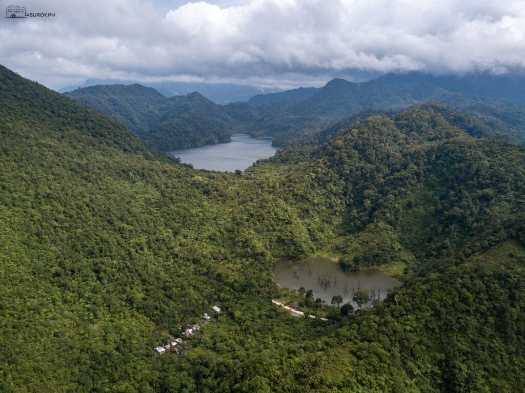 A stunning panoramic shot of the Balinsasayao Twin Lakes Nature Park in Sibulan, with one lake in the foreground and another in the background, framed by the lush mountains.