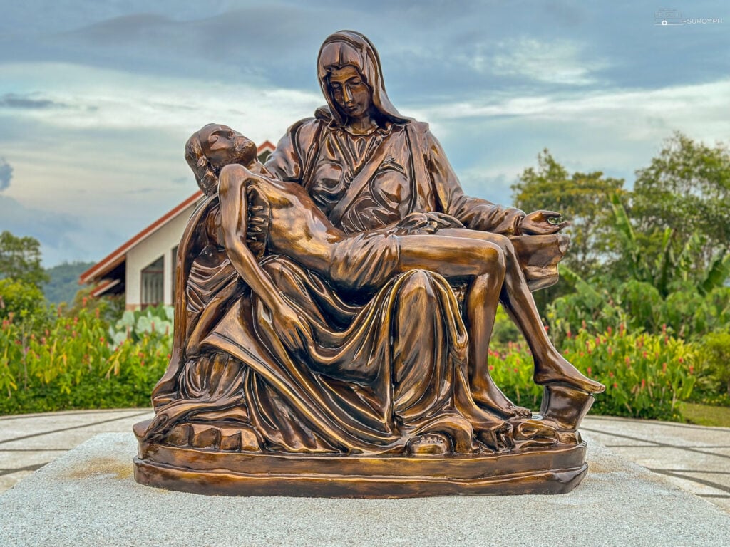 La Pietà depicts the Virgin Mary cradling the lifeless body of Jesus Christ after his crucifixion. It is the centerpiece of MagSpeak Mountain Resort.