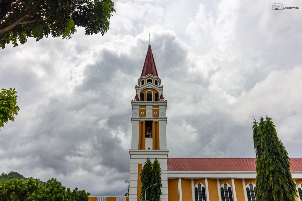 A serene view of The Transfiguration of Our Lord Cathedral, framed by lush greenery and a sky full of promise.