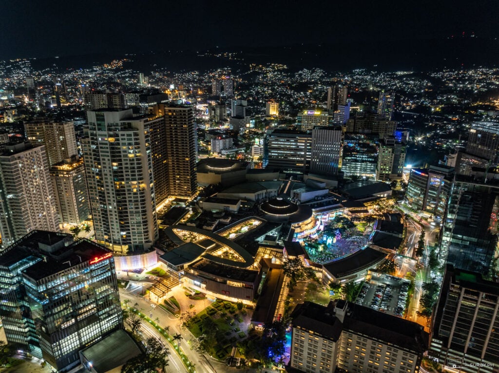 A breathtaking aerial view of Cebu Business Park, showcasing Ayala Center Cebu and the surrounding cityscape illuminated beautifully at night.