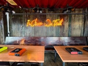 Inside Fat Dois in Parkmall Mandaue, the ambiance is set with the glowing neon sign “In Cheese We Trust,” preparing you for a delicious experience.