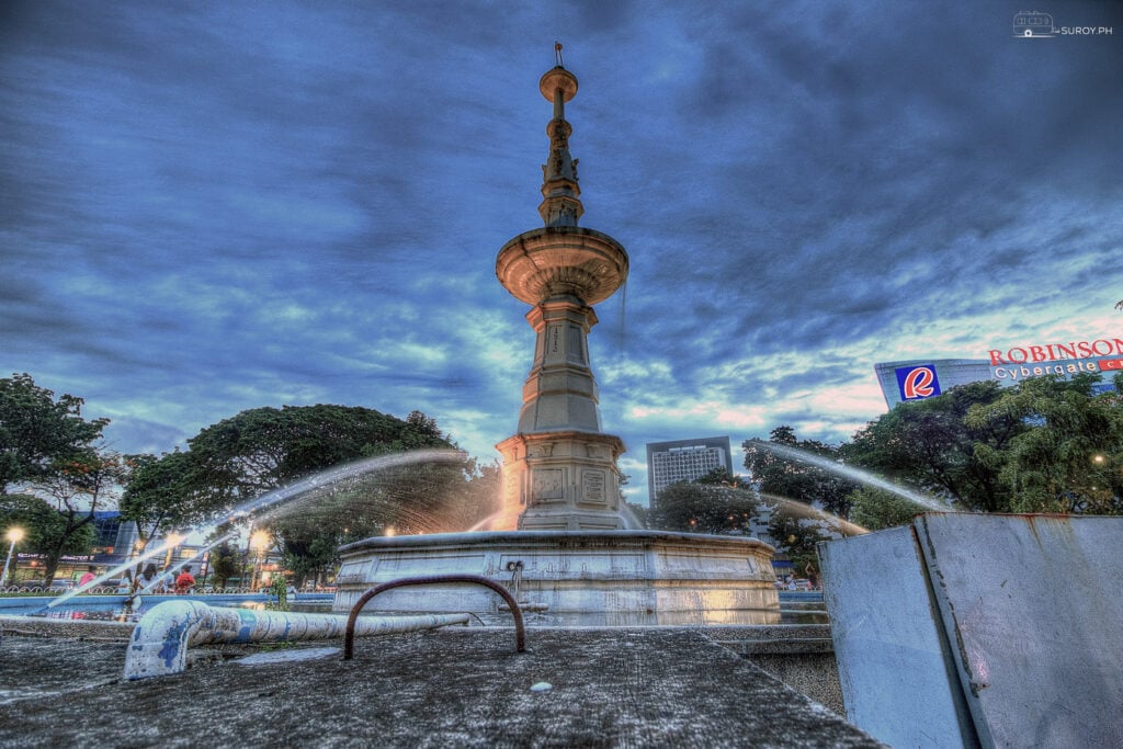 A stunning view of the iconic Fuente Osmeña Circle fountain, beautifully illuminated against the evening sky.