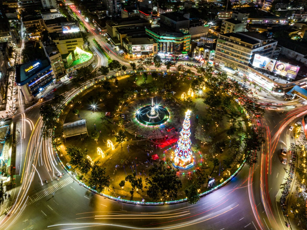 A mesmerizing aerial shot of Fuente Osmeña Circle at night, illuminated by the city lights and festive decorations.