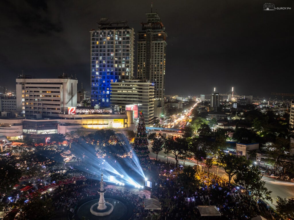 A dazzling view of Fuente Osmeña Circle at night, with vibrant holiday lights and bustling crowds.