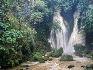 A picturesque view of the cascading waters at Mag-Aso Falls in Kabankalan, surrounded by verdant foliage.