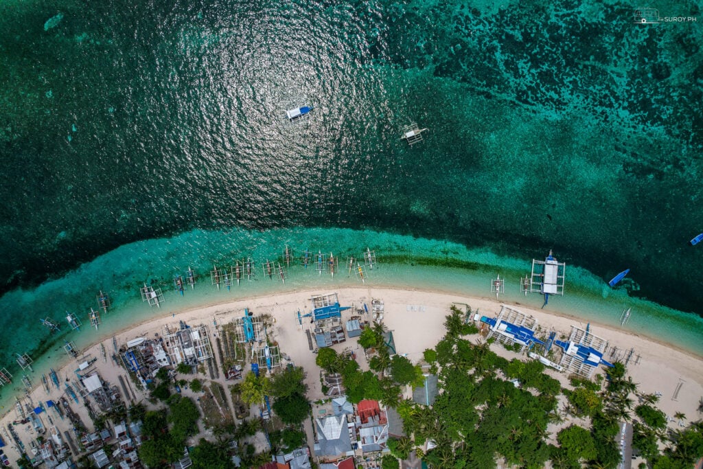 Traditional boats lined up on the shores of Malapascua Island, ready to take you on an unforgettable adventure.