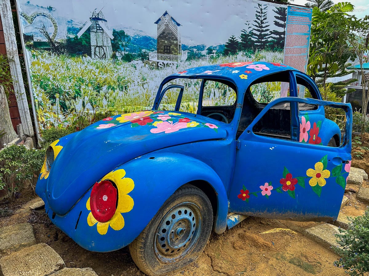 A blue Volkswagen Beetle parked in the beds at Sirao Garden as a photo prop.