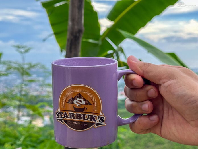 Sipping coffee from a Starbuk’s Kapehan mug while enjoying the beautiful scenery.