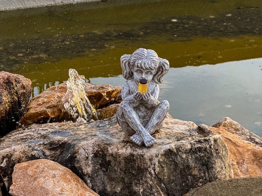 A charming statue greets visitors at Tuburan 360, adding a touch of whimsy to the serene gardens.