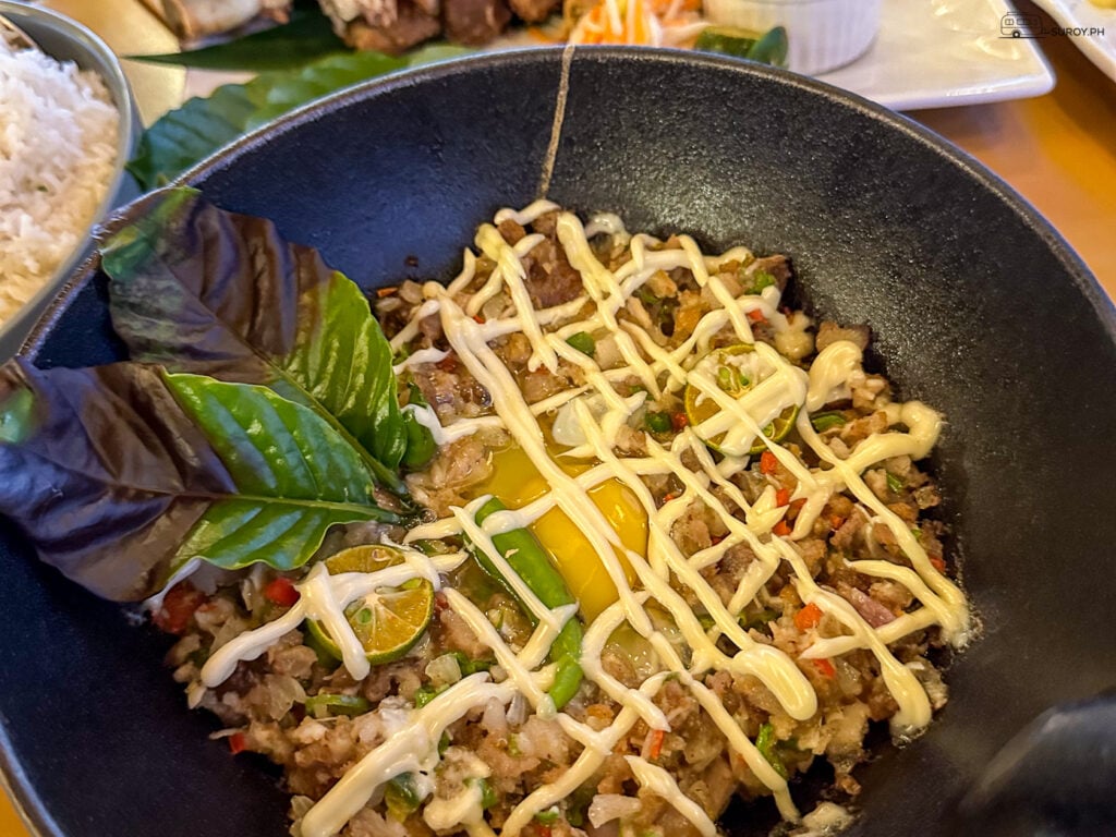 Enjoy a bowl of sizzling sisig, one of the many mouth-watering dishes at Tuburan 360. Every bite is a burst of flavor! 