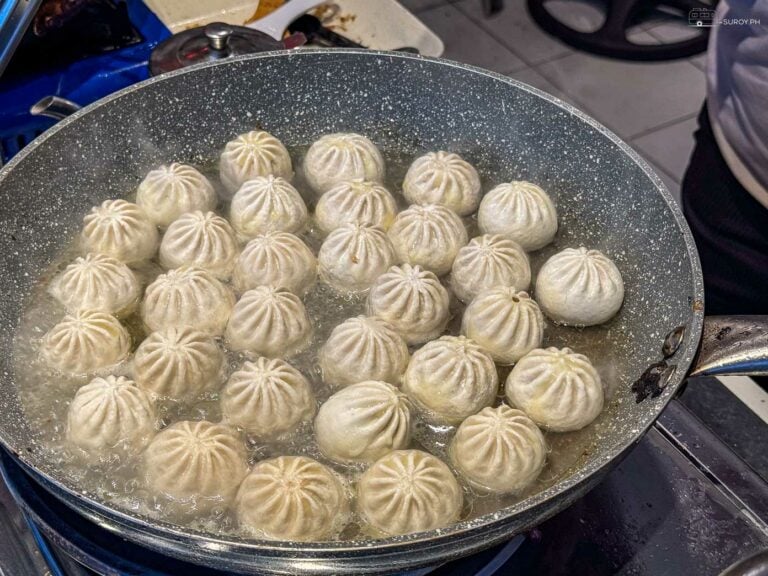 Fresh Xiao Long Bao being pan-fried to golden perfection, sealing in all the juicy goodness.