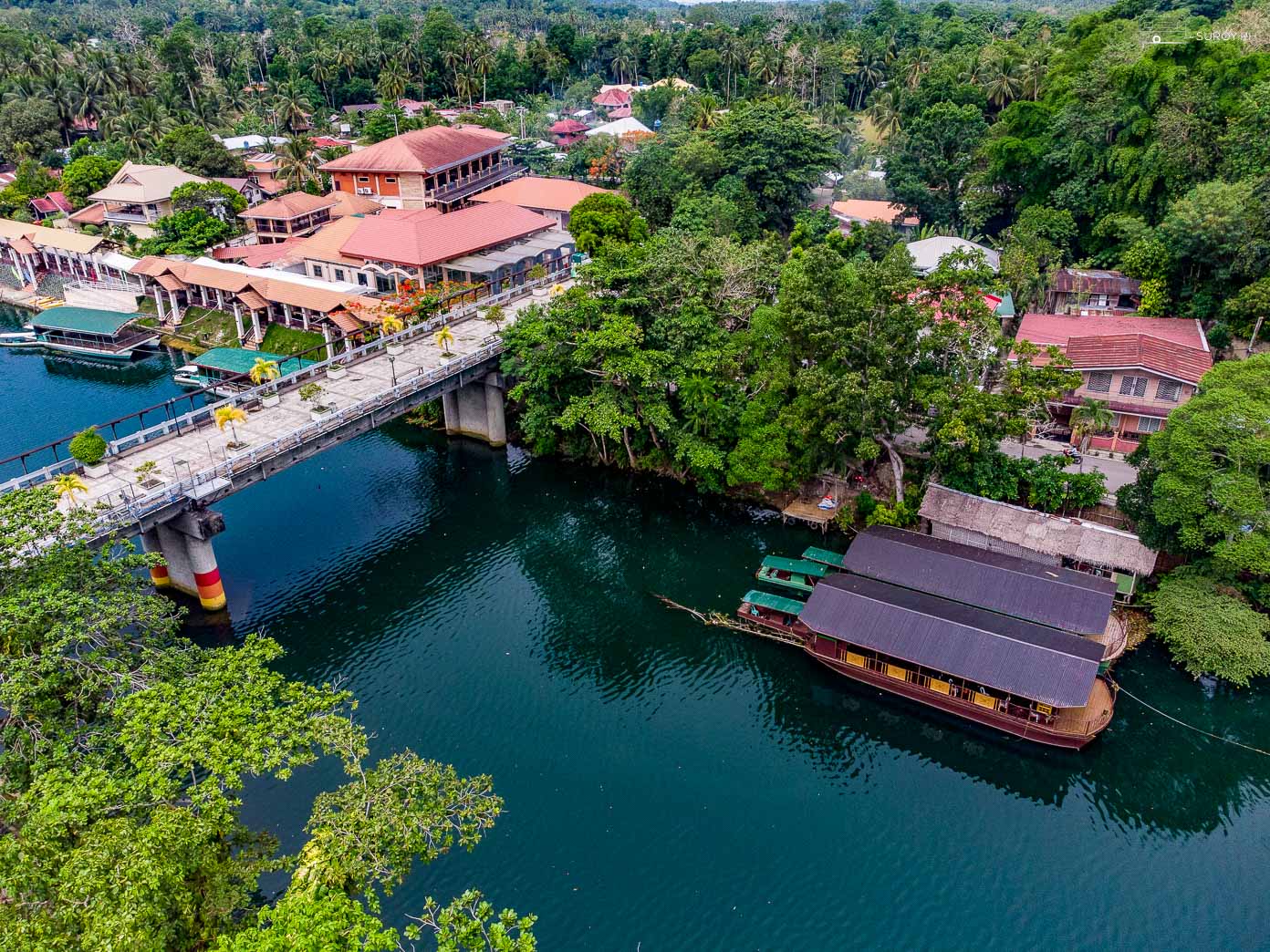 Aerial view of the Loboc River in Bohol, showcasing the scenic landscape and floating restaurants that await visitors on the cruise.