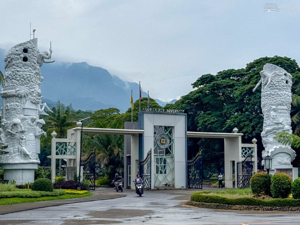 Entrance of Visayas State University: The grand entrance of VSU, flanked by towering sculptures, welcomes visitors to the scenic and prestigious campus with the majestic Mount Pangasugan in the background.