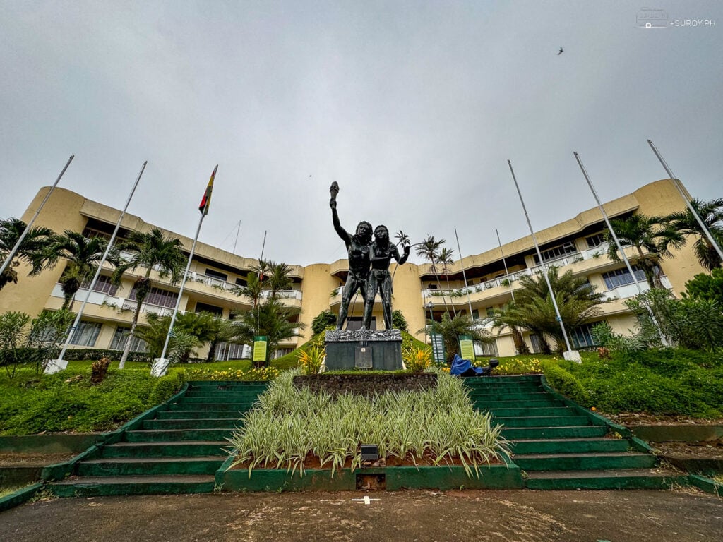 VSU Administration Building: The impressive administration building of Visayas State University in Baybay, Leyte stands proudly in front, with a statue symbolizing the pursuit of knowledge and excellence.