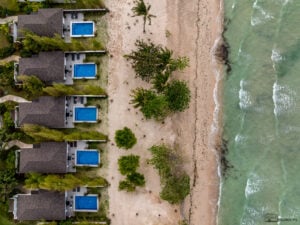 A scenic aerial view of Kandaya Resort’s luxurious beachfront villas, each with a private pool and direct access to the white-sand beach—perfect for a serene getaway.