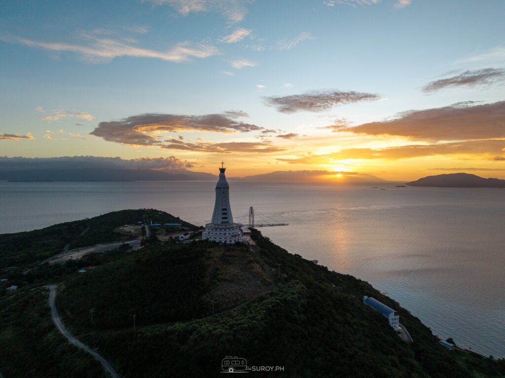 As dawn breaks over Montemaria Shrine, the tranquil waters and surrounding islands create a serene atmosphere perfect for reflection and prayer.