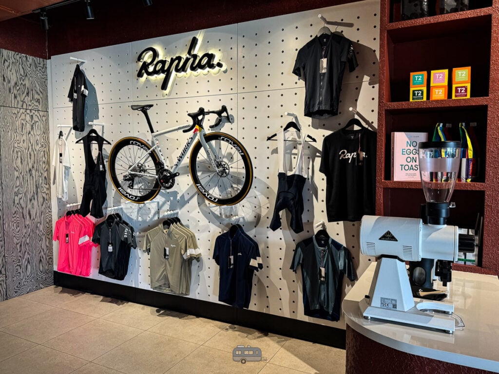 Rapha cycling gear wall with a road bike on display inside Punched Coffee.