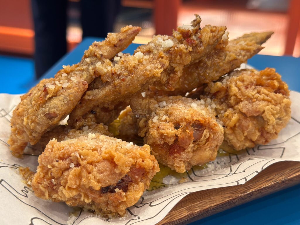 A pile of garlic parm chicken wings on paper at 8Cuts SM City Cebu