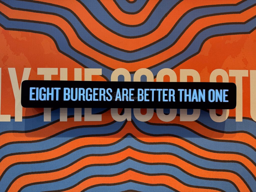The orange and blue wave graphic on the 8Cuts Cebu wall carrying the line eight burgers are better than one