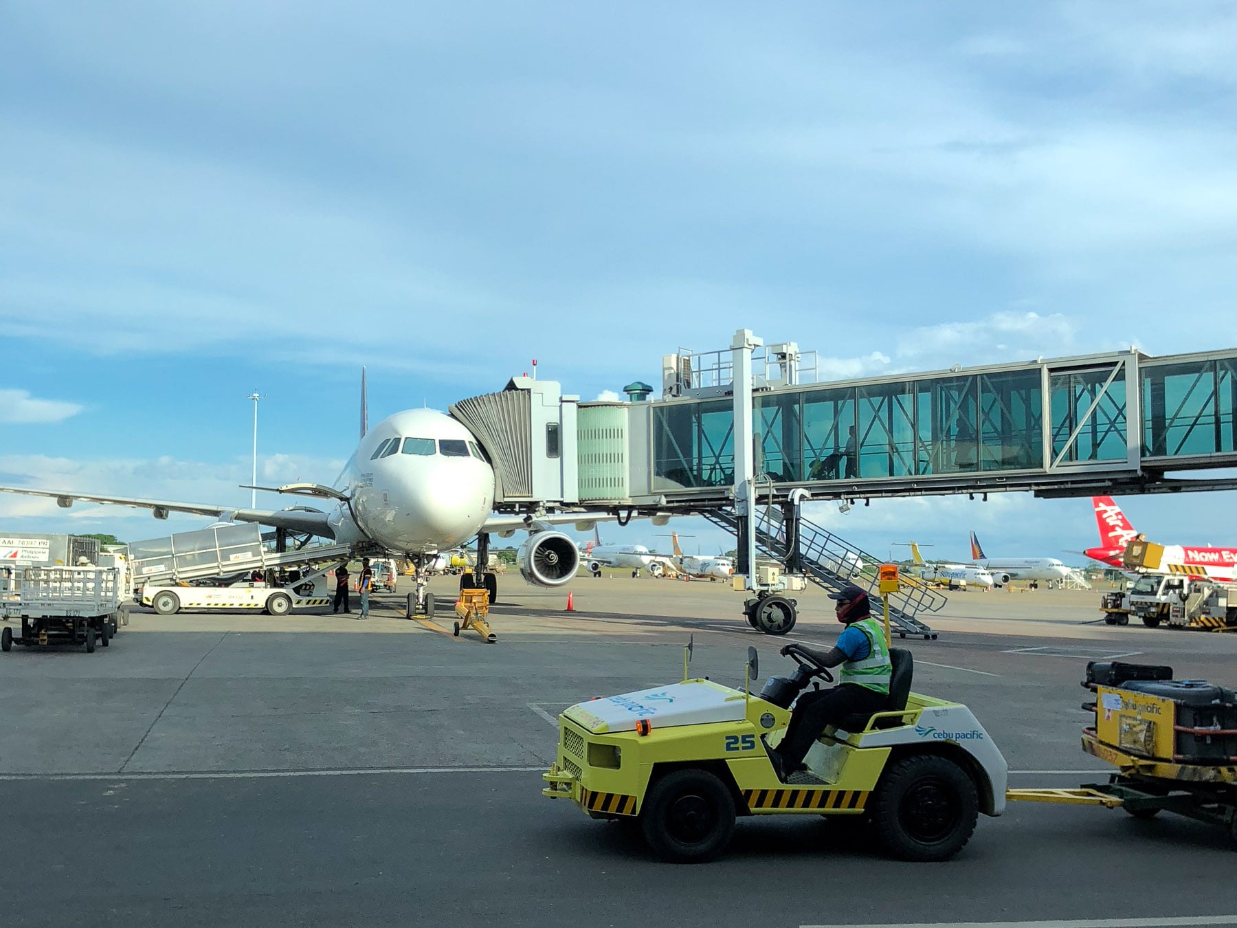 Aircraft, ground crew, and service vehicle at Mactan-Cebu International Airport