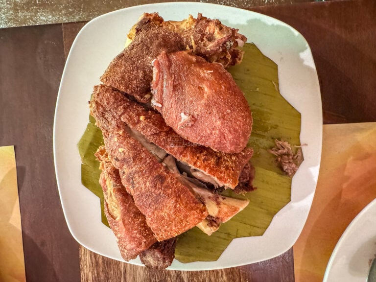 A whole crispy pata on banana leaf on a white platter at Alejandro's Crispy Pata in Cebu City