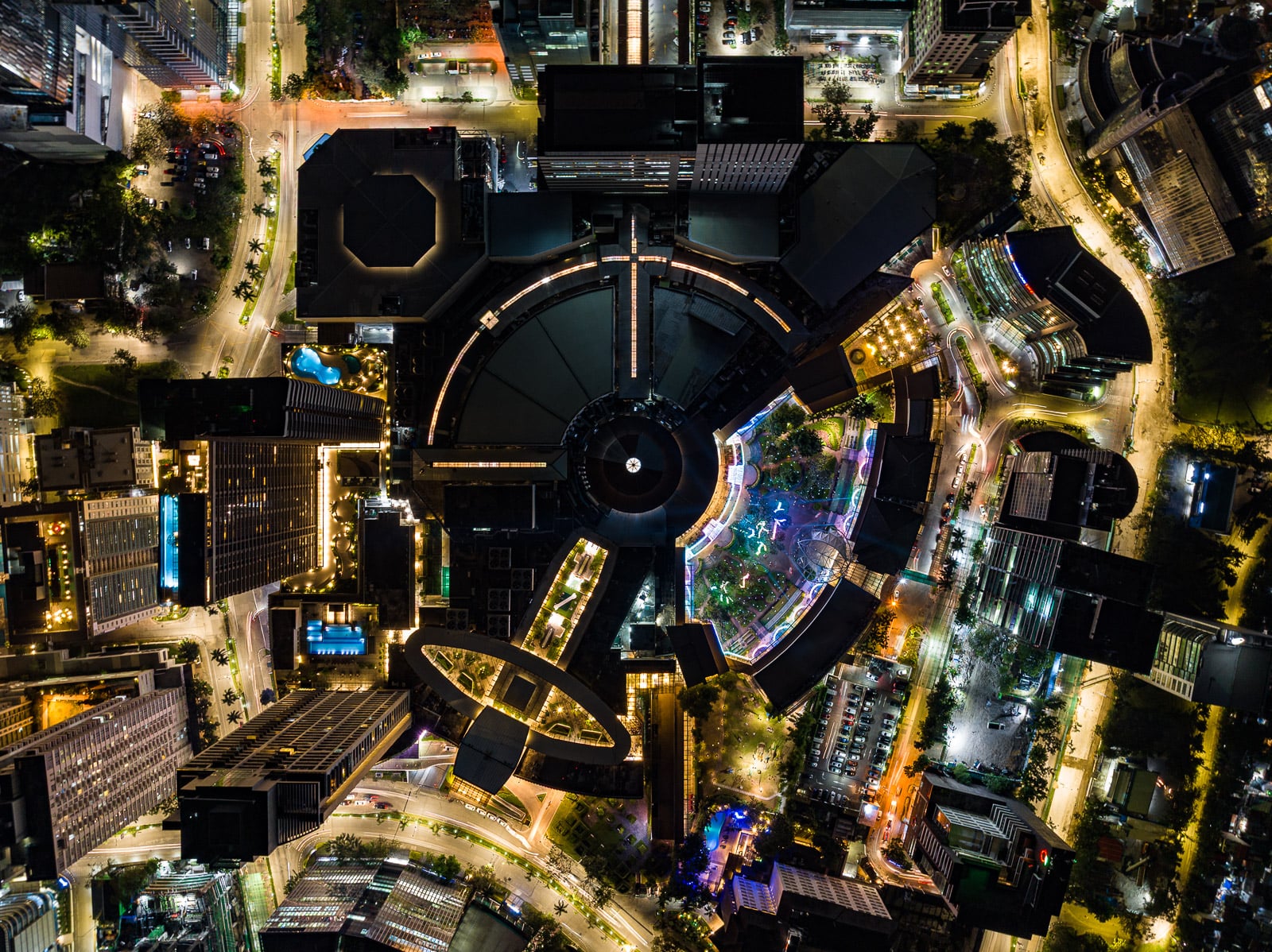 Top-down aerial night view of Ayala Center Cebu with the Terraces gardens lit in color by the Christmas light show.