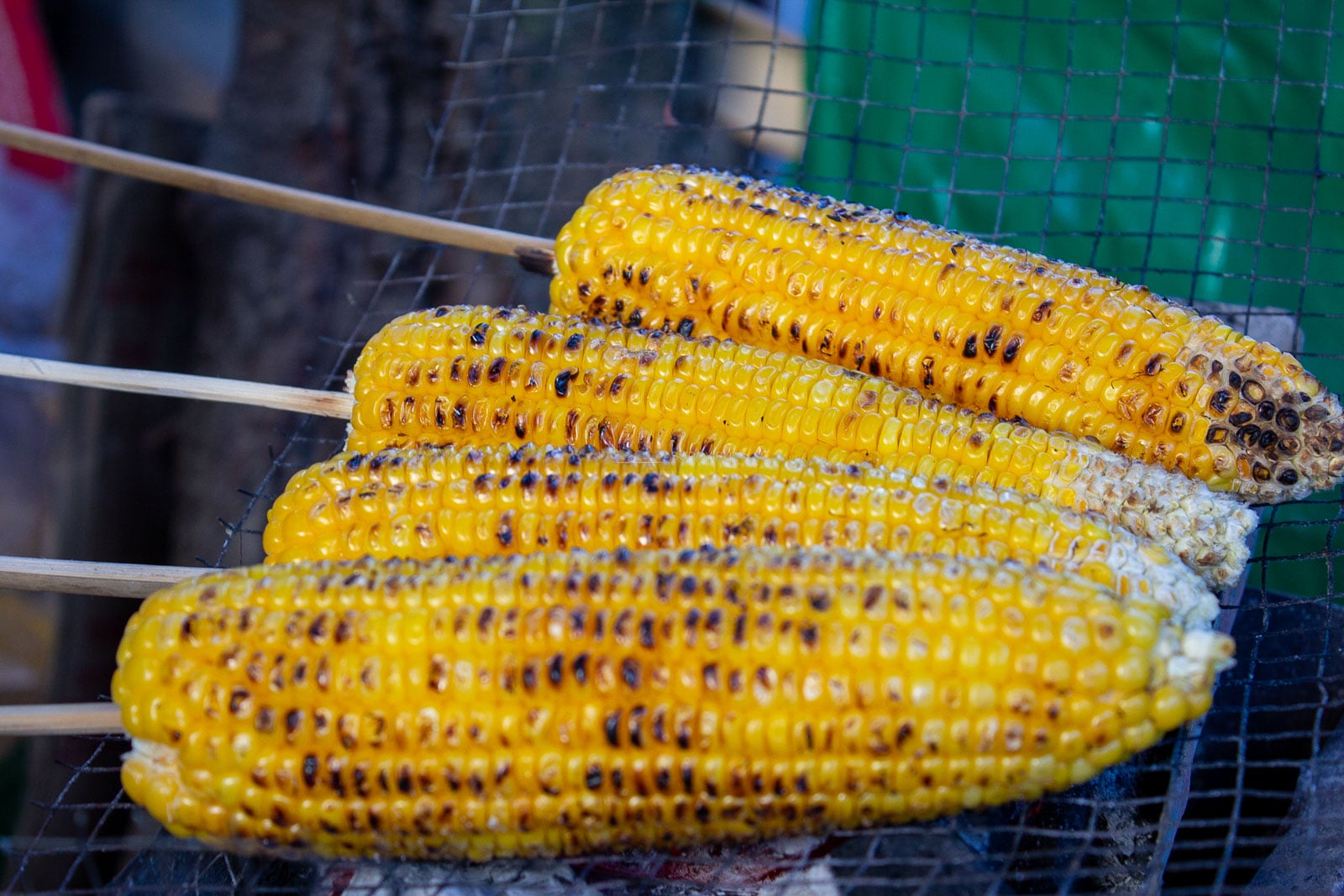 Corn grilling over a rack at a Baguio food stall