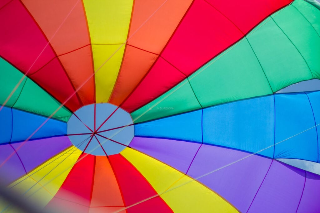 Close view of the underside of a rainbow-striped parasail canopy