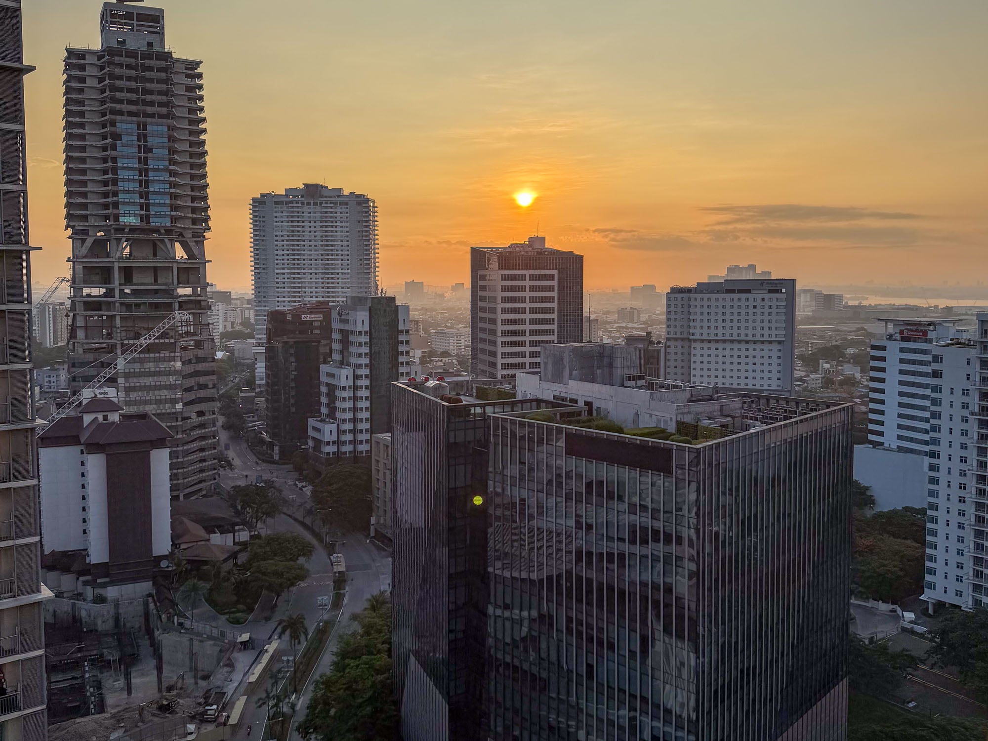 Sunrise over the towers of Cebu Business Park and the harbor beyond, seen from above Ayala Center Cebu.