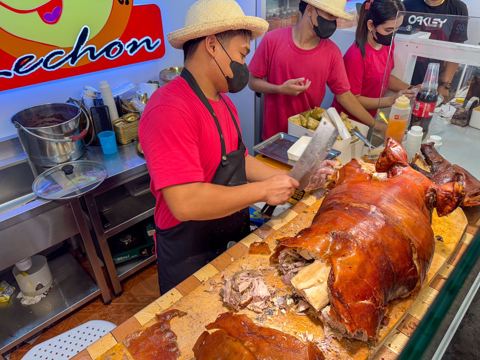 A vendor chopping Cebu lechon at a food stall inside Pusô Village