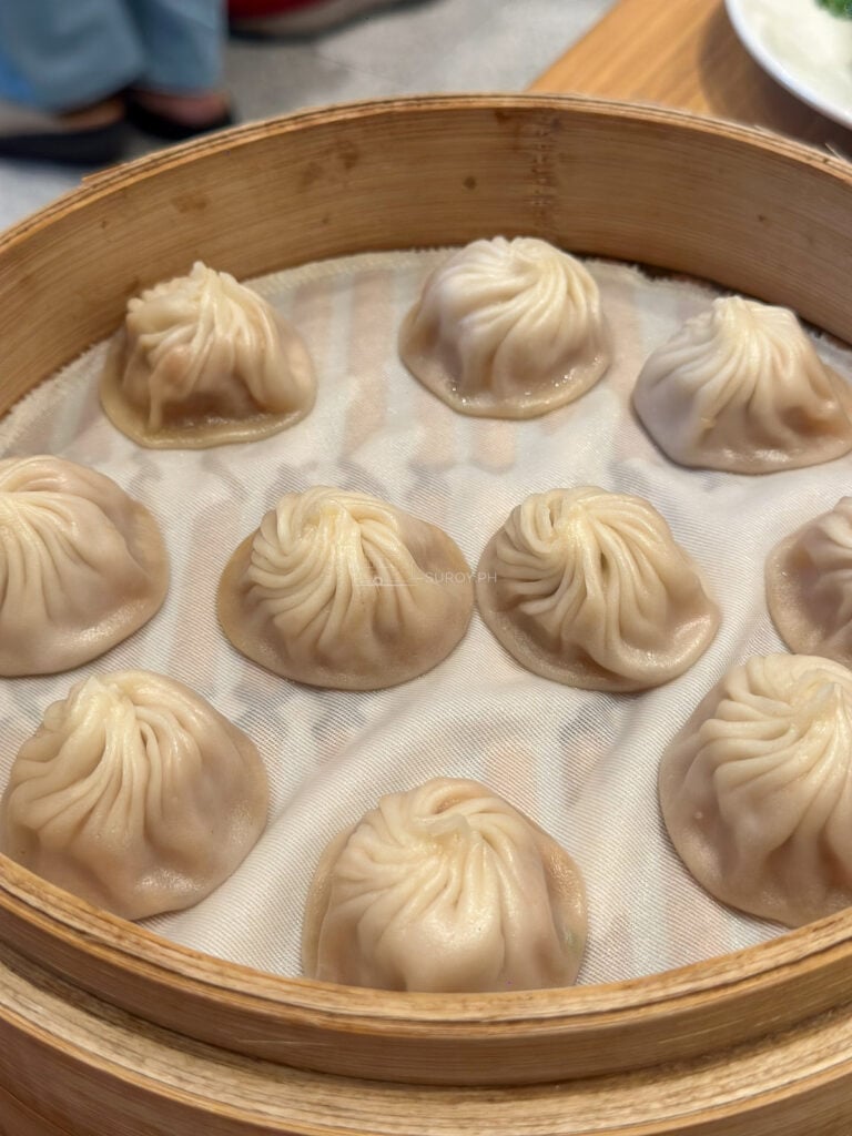 A bamboo steamer of pork xiaolongbao at Din Tai Fung SM City Cebu, each dumpling pleated closed at the top