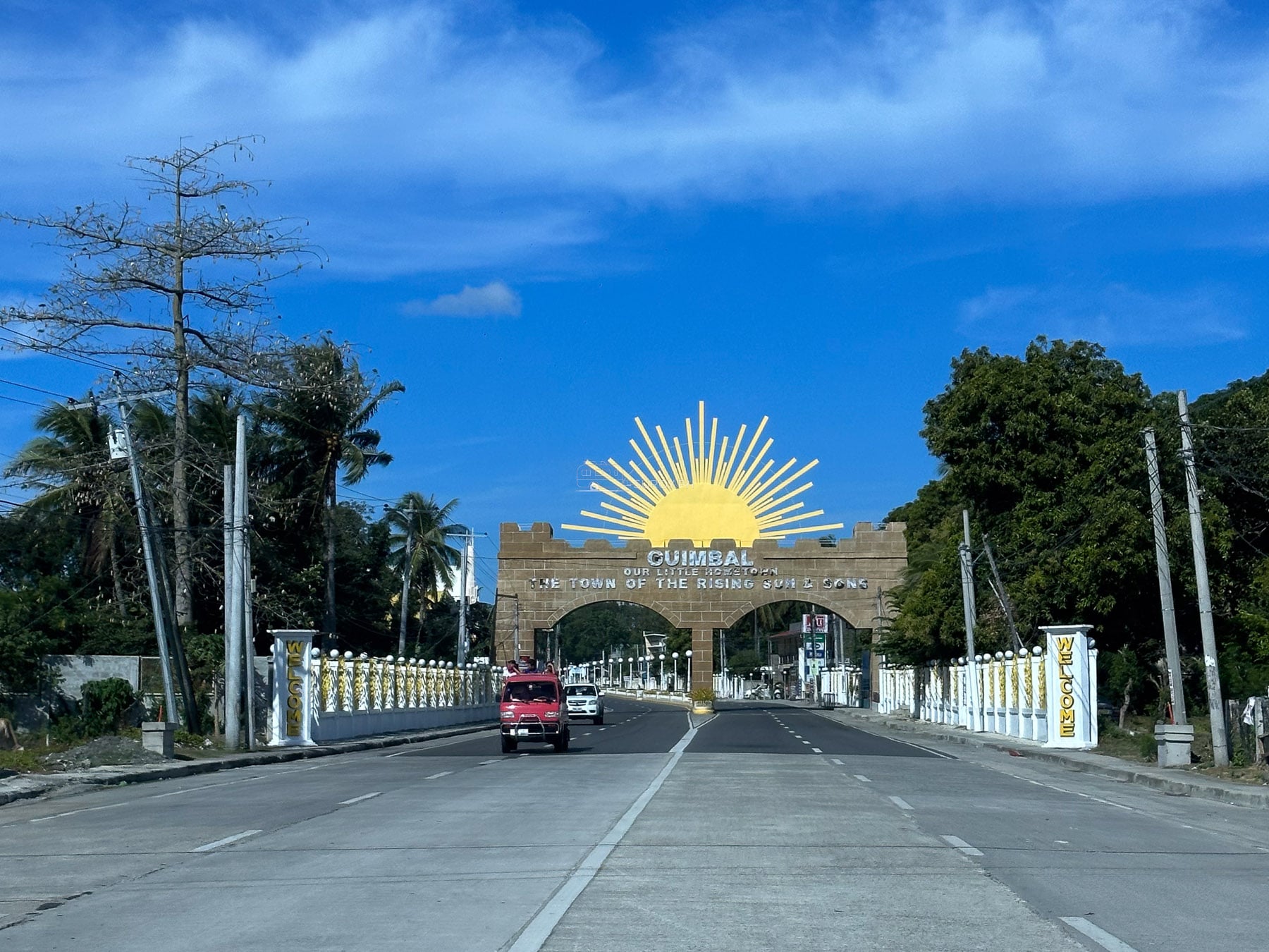 Guimbal gateway with a rising sun above the road