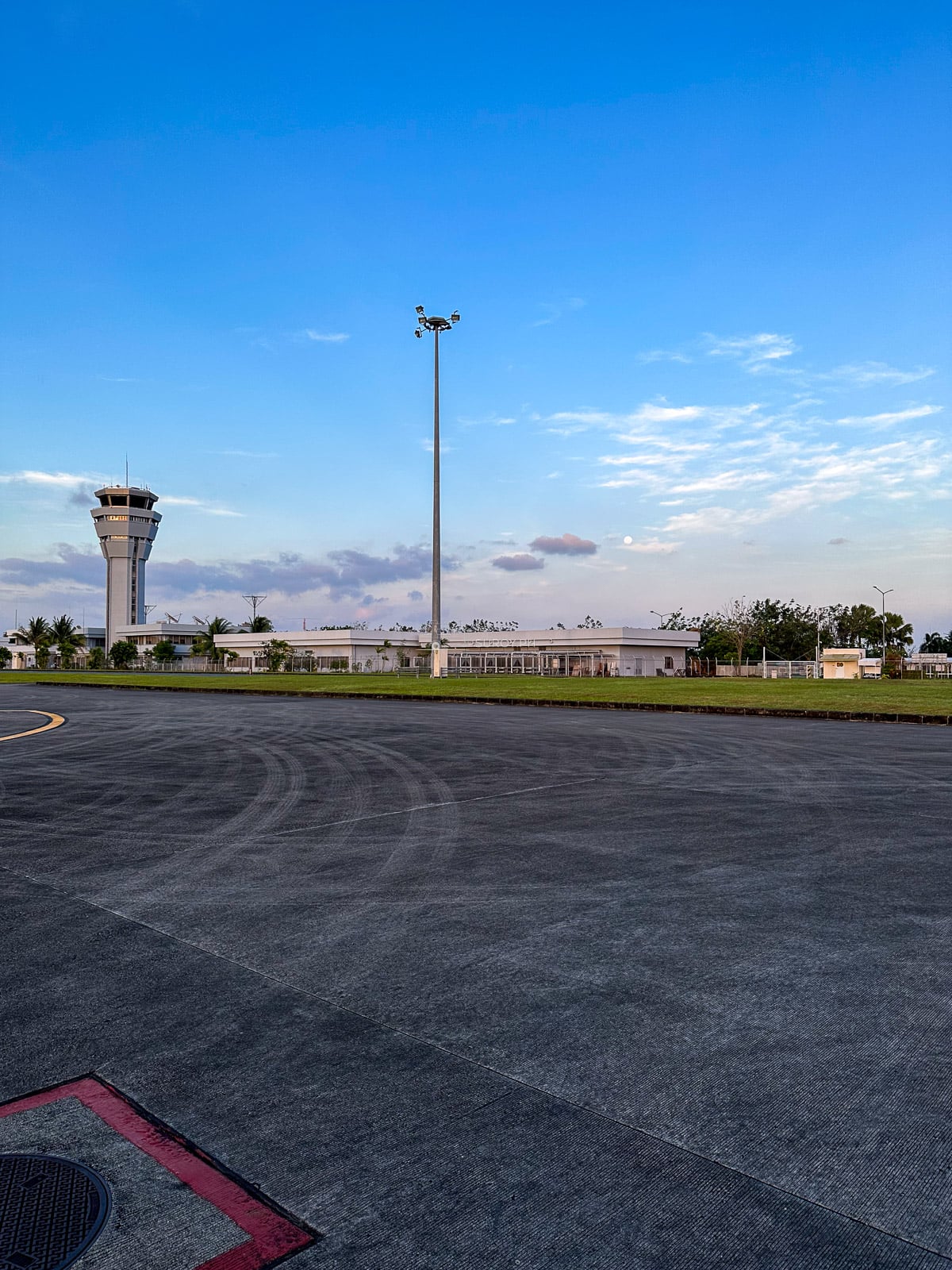 Air traffic control tower beside the Iloilo Airport apron under a blue sky
