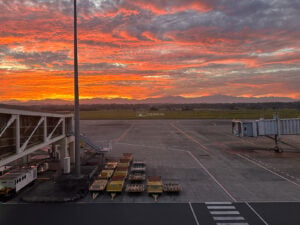 Iloilo Airport apron and jet bridges beneath an orange sunset