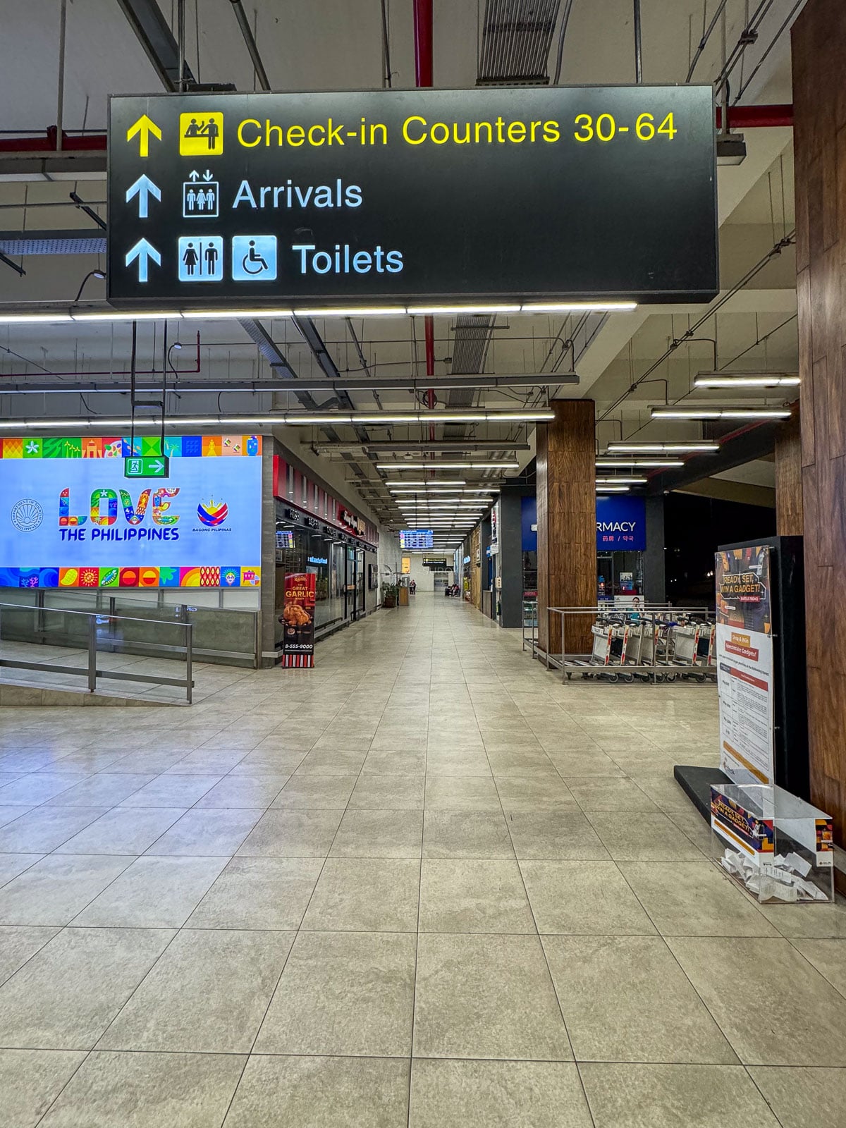 Wayfinding signs for check-in counters, arrivals and toilets inside Mactan-Cebu International Airport