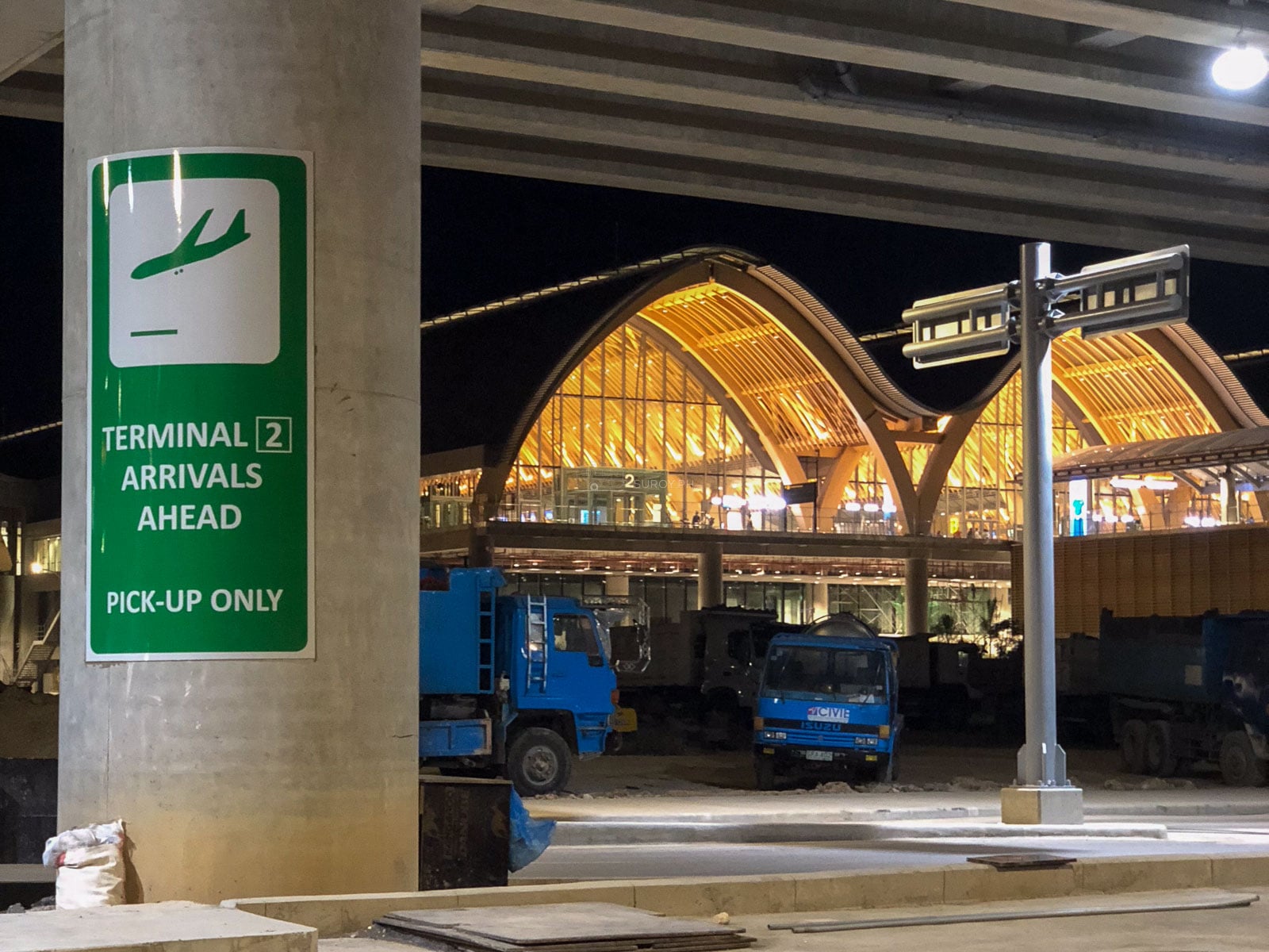 Terminal 2 Arrivals Ahead pickup sign at night