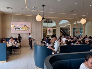 The Manam dining room at SM City Cebu with arched openings, deep blue banquettes, globe pendants and a full lunch service