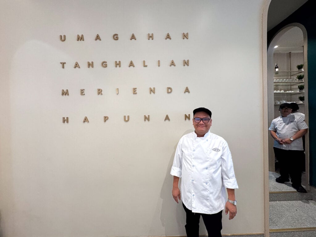 The four Filipino meal names set into the plaster wall by the entrance at Manam SM City Cebu, with a chef in whites standing beside them