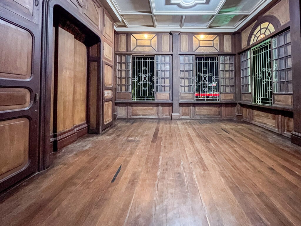 Interior hall of Molo Mansion in Iloilo with a polished wooden floor, tall doors and shuttered windows