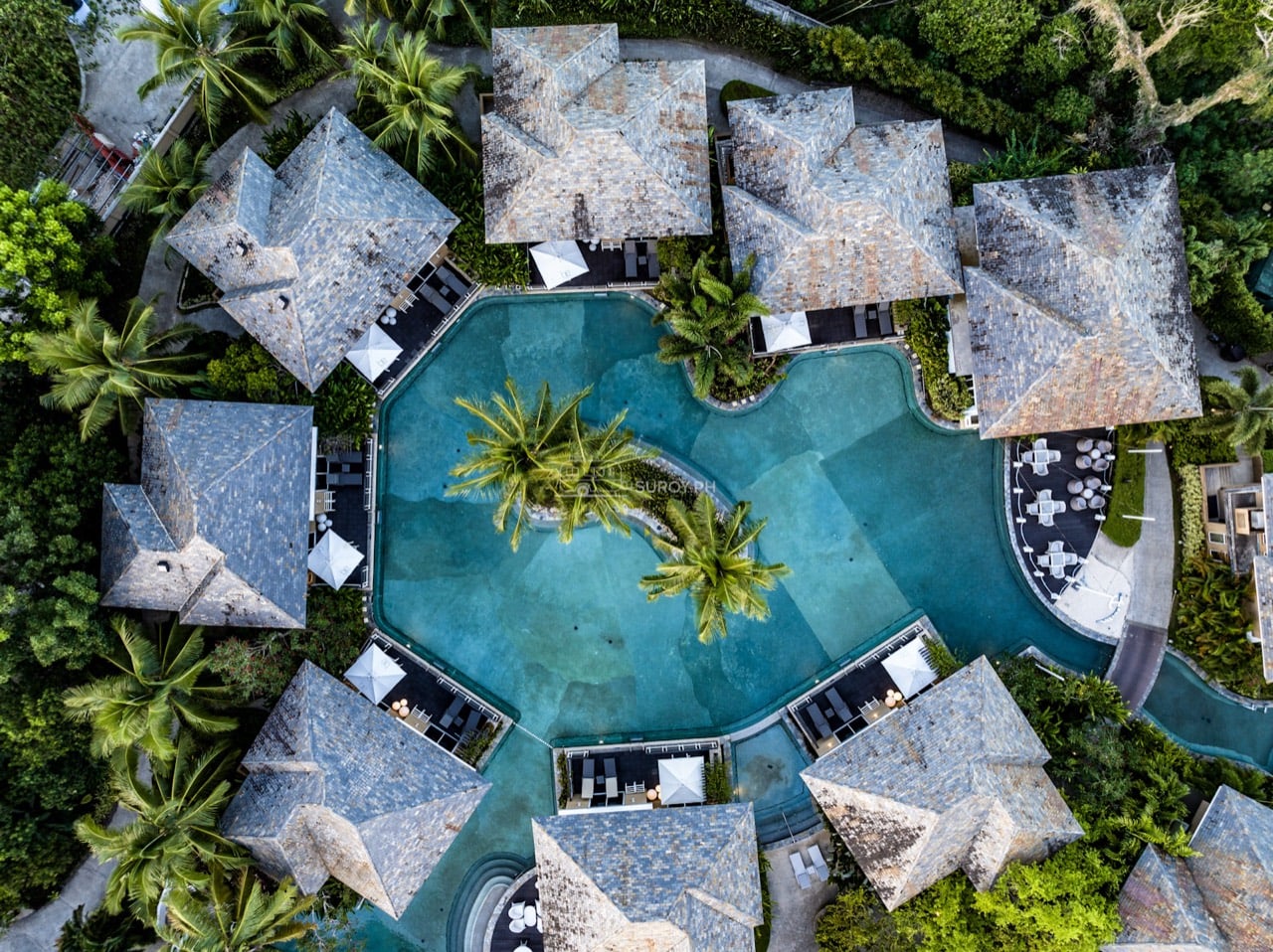 Aerial view of resort villas surrounding a lagoon-shaped swimming pool in Panglao