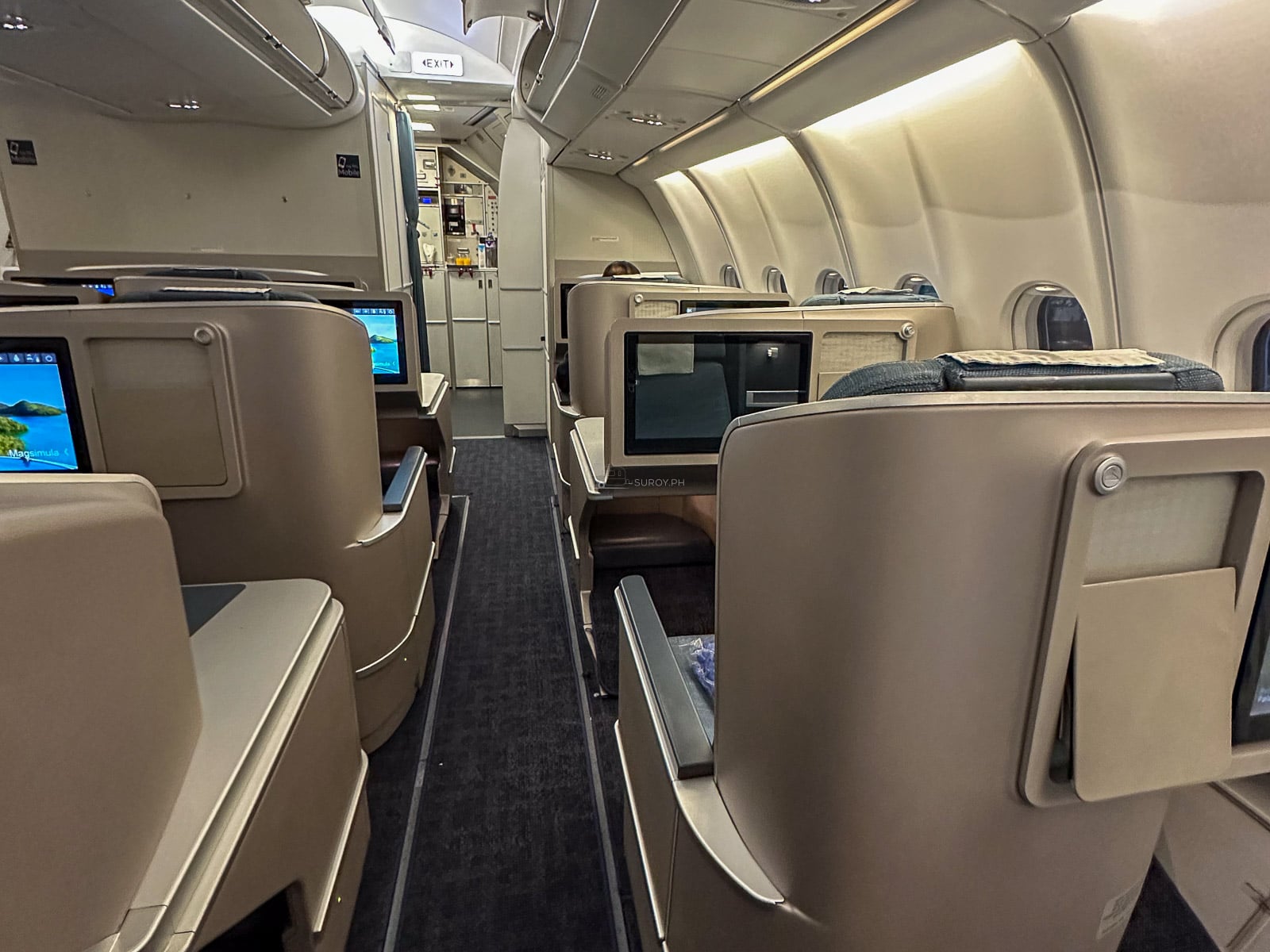 Philippine Airlines business-class cabin with rows of seats and personal screens